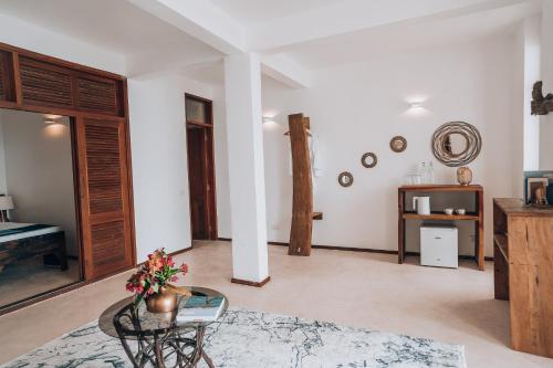 ein Wohnzimmer mit einem Tisch und ein Zimmer mit einem Bett in der Unterkunft ZAN Paradise Jambiani Beach in Makunduchi