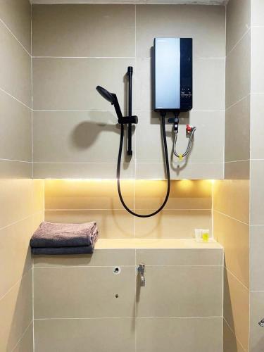 Un baño con ducha y un televisor en la pared. en urban studios, en Phnom Penh