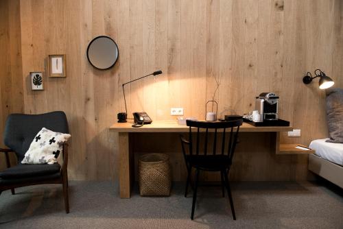 a room with a desk with a bed and a chair at Mooirivier in Dalfsen