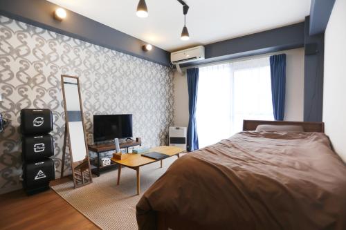 - une chambre avec un lit, un miroir et une télévision dans l'établissement BetterЯ03青森橋本203号室, à Aomori