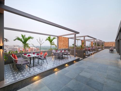 a patio with tables and chairs on a building at Pride Elite Gandhinagar in Gandhinagar