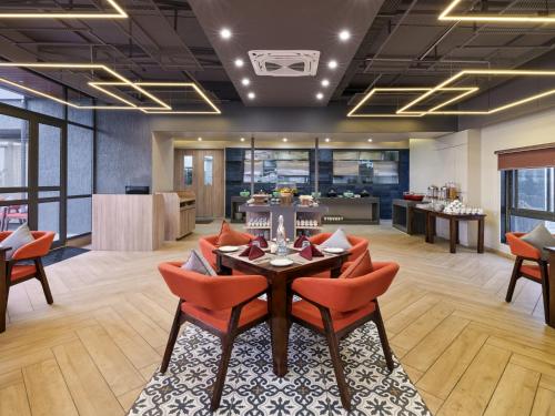 an office lobby with a table and chairs and a kitchen at Pride Elite Gandhinagar in Gandhinagar