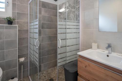 a bathroom with a sink and a shower at Villa Le Manguier - Logement Manka, Piscine privée in Goyave