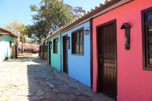 una fila de casas coloridas en una calle en Pousada Vila Cipó, en Serra do Cipo