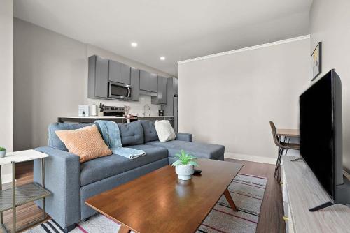 a living room with a blue couch and a table at CozySuites Marquee in Minneapolis