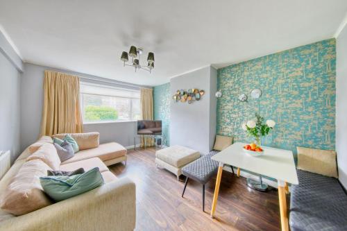 a living room with a couch and a table at 2 bed flat - SW London with parking in Teddington