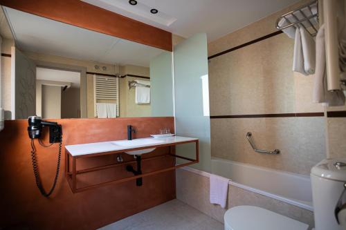 un bagno con lavandino e specchio di Hotel Centro Los Braseros a Burgos