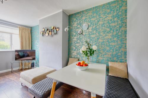 a living room with a table and a couch at 2 bed flat - SW London with parking in Teddington