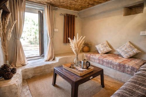 a living room with a couch and a table at The Gypsy Soul Mukteshwar in Mukteshwar