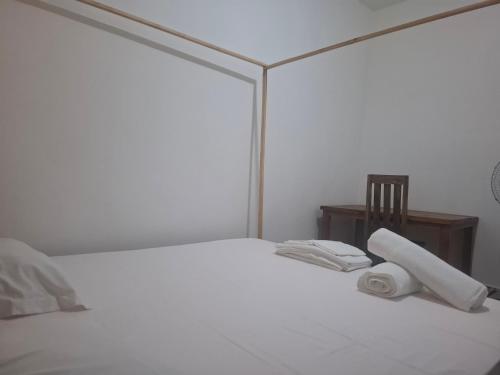 a white bed with a roll of toilet paper on it at Bee Rooms Nosy be in Ambatoloaka