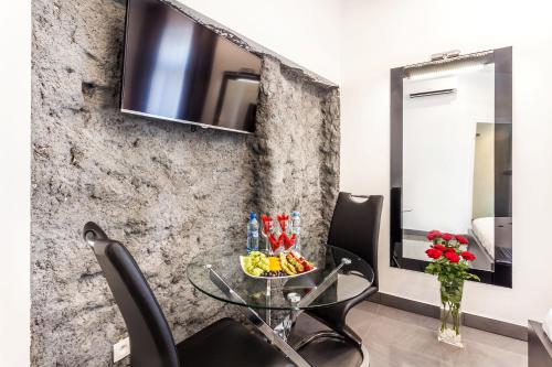 a dining room with a glass table and chairs and a mirror at Komorowski Luxury Guest Rooms in Kraków