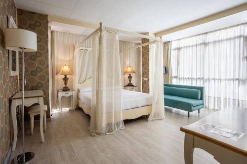 una camera con letto a baldacchino e sedia blu di Hotel Centro Los Braseros a Burgos