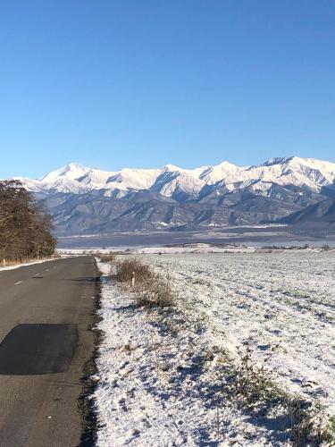 una strada innevata con montagne sullo sfondo di Warm Welcome a İvanovka