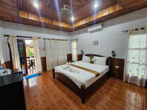 een slaapkamer met een groot bed in een kamer met houten vloeren bij Lanta White Rock Resort in Koh Lanta