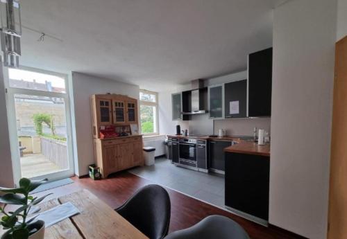 a kitchen with black appliances and a wooden table at Süße Marie 3 in Karlsruhe