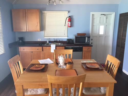 a kitchen with a wooden table with chairs and a dining room at The Sands Hotel in Cockburn Town
