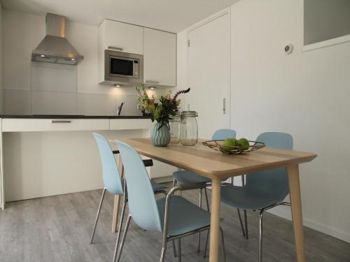 una cucina con un tavolo di legno e sedie blu di Stunning apartment in Schoorl, North Hollandâ you can bike to the beach a Schoorl