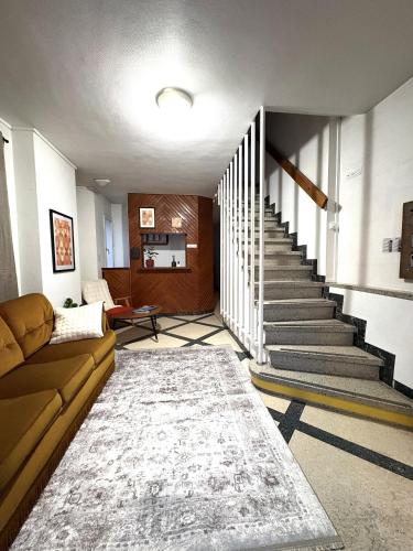 a living room with a couch and a staircase at Les Loges du Vercors in Vizille