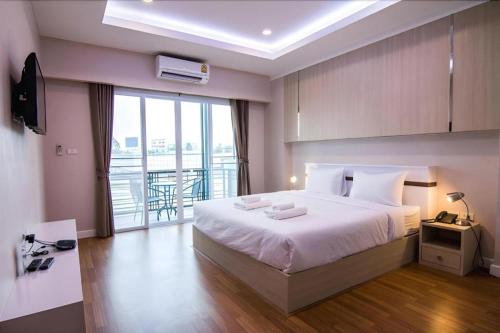 una camera da letto con un letto grande e un balcone di At Home at Udon a Udon Thani