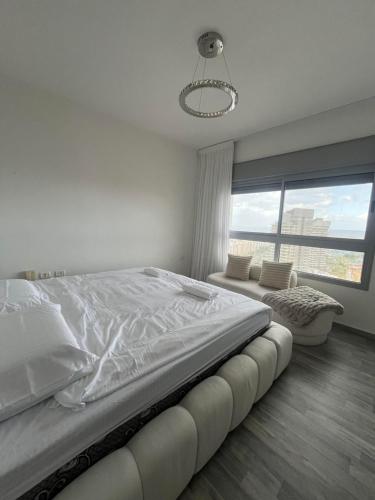 een witte slaapkamer met een groot bed en een raam bij Your Next Premium Stay In Ashdod in Ashdod