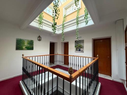 une pièce avec un escalier avec une grande fenêtre dans l'établissement Hostal Bahía, à Cadix