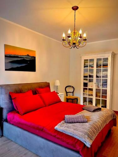 a large red bed in a bedroom with a chandelier at Luxury 3 bedroom Grand Chalet in Perosa Argentina