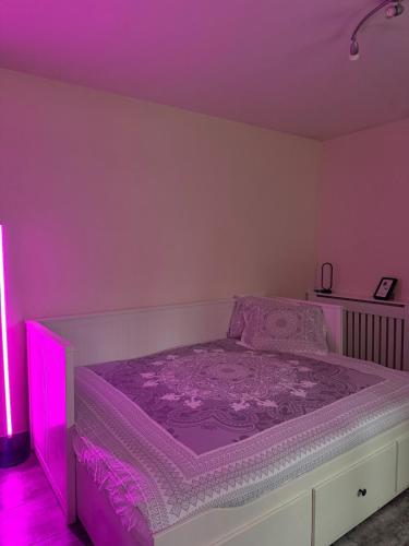 een slaapkamer met een bed met paarse verlichting erop bij Studio cosy et calme à Garches in Garches