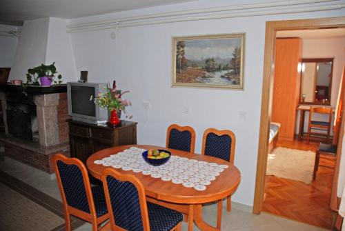 een eetkamer met een tafel en stoelen en een televisie bij Apartment Vito in Bovec