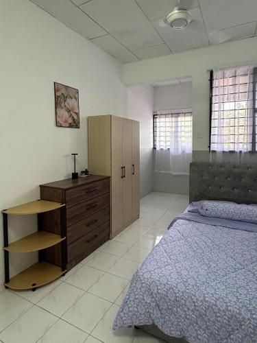 a bedroom with a bed and a wooden cabinet at Miraana Nest in Sungai Petani