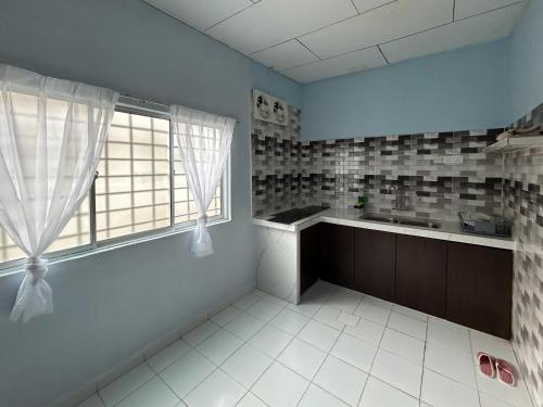 a kitchen with a sink and a window at Miraana Nest in Sungai Petani