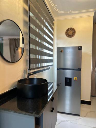 a kitchen with a sink and a refrigerator at Sunset Statehouse View Residence A in Entebbe