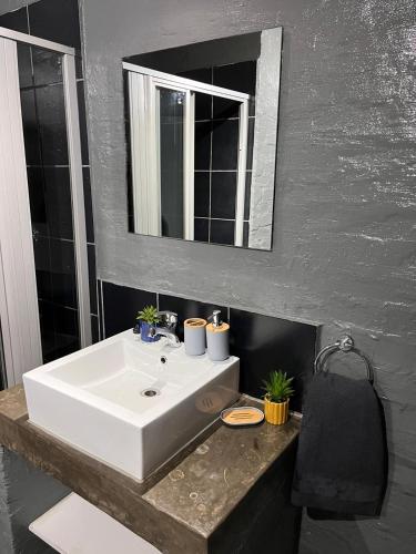 a bathroom with a white sink and a mirror at Craftsmanship Unit 235 in Johannesburg