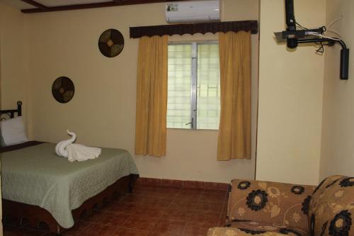 a bedroom with a bed and a window with a swan on it at Hotel Valle Verde in Valle de Anton