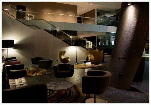 a lobby with a bunch of chairs and a staircase at Casa Grande Hotel in La Paz