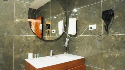 un bagno con lavandino e specchio di Hotel Mitra Inn a Kathmandu