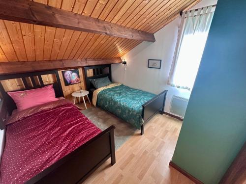a bedroom with a bed and a wooden ceiling at Le Chalet des 4 Chouettes in Gérardmer