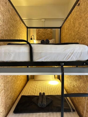 a bunk bed with a pair of shoes on the bottom bunk at Sunnies 24 in Phra Ae beach