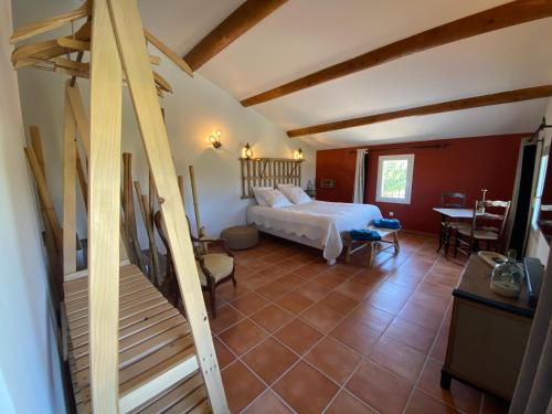 a bedroom with a bed and a staircase in a room at Très beau mas provençal entièrement rénové Piscine & SPA entre Dentelles & Ventoux in Violès