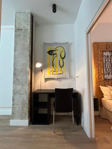 a desk in a room with a painting on the wall at La Baltasara Apartments in Valladolid