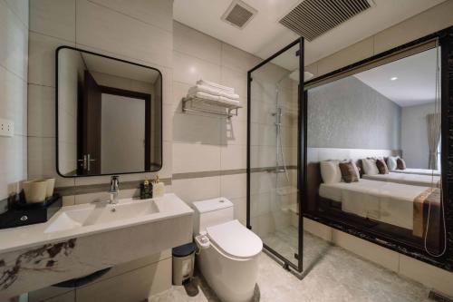 un bagno con lavandino, WC e letto di Véra Stay - Cat Ba a Cat Ba