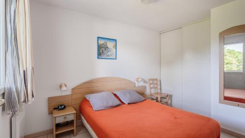 a bedroom with a bed with an orange blanket at Allee des Dunes E N57 3P6 in Ondres