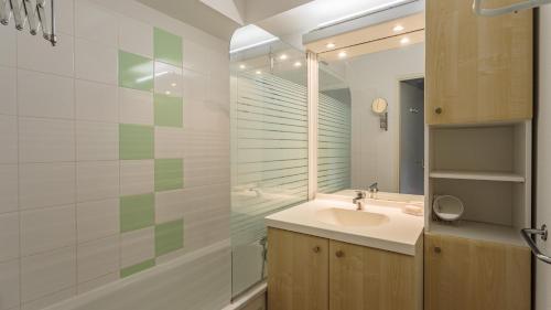 a bathroom with a sink and a shower and a mirror at Allee des Dunes E N57 3P6 in Ondres