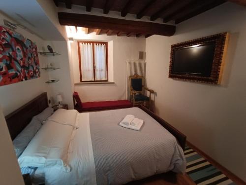 een slaapkamer met een bed en een flatscreen-tv bij Casa via dei Longini in Città di Castello