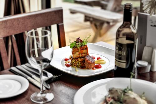 a table with a plate of food and a bottle of wine at Narrowboat at Weedon in Weedon Bec