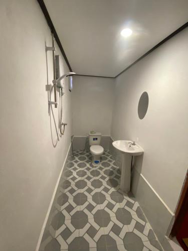 a bathroom with a toilet and a sink at Thavisok Guest House in Nongkhiaw