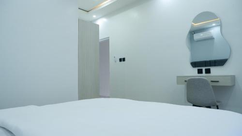 a white room with a desk and a chair at Villa Dalia Puncak Na5-06 in Cikundul