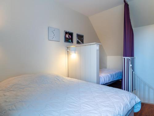 a bedroom with a bed and a cabinet and a staircase at Sud Ocean J N74 2P4 in Guidel