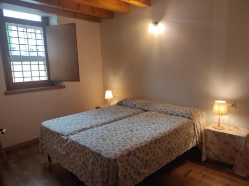 una camera da letto con un letto e due lampade su due tavoli di Grazioso appartamento con giardino e posto auto a Belluno