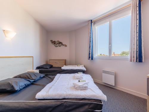 two beds in a room with a window at L Ocean N40 2P5 in La Tranche-sur-Mer