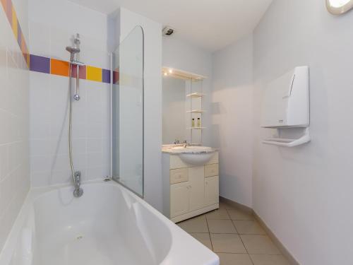 a white bathroom with a tub and a sink at L Ocean N40 2P5 in La Tranche-sur-Mer